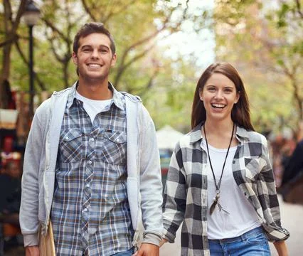 They enjoy the same things. A young couple walking hand in hand. Stock Photos