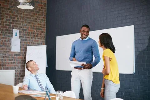 They make a great team. three businesspeople in the office. Stock Photos