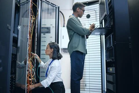 They make a great team. two young computer programmers working together in a Fotos Stock