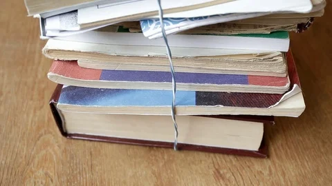 They remove a stack of books from the shelf and lay down the tablet, a close Stock Footage 115624432