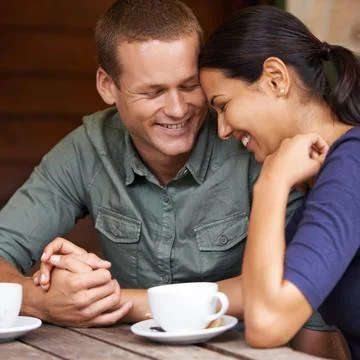 They share the same silly humour. A young multi-racial couple laughing together Stock Photos
