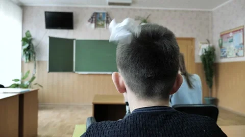 They throw paper at the child at school. Teenager offended at school. Bullying Vídeos de archivo 131270950