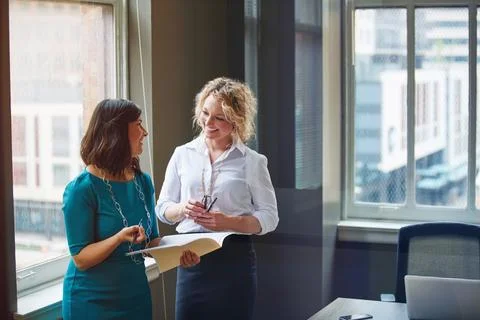 Theyre proactive in problem solving. two businesswomen going over paperwork Foto stock
