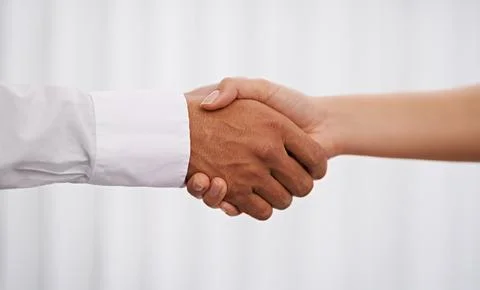 Theyve come to an agreement. two hands joining for a hand shake. Stock Photos