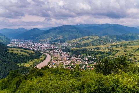 Thick and dense clouds in the sky floating above the mountains and the town b Stock Photos