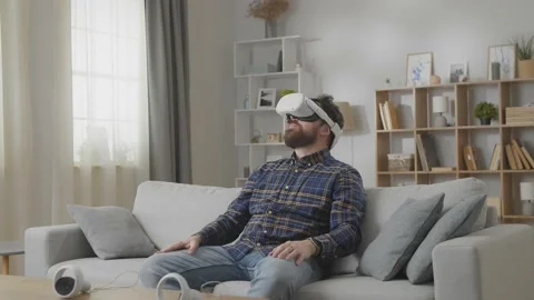Thick and fat man using his VR headset for watching the 360 video while sitting Stock Footage 169320881