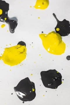 Thick and shiny splashes of black and yellow paint scattered. Stock Photos