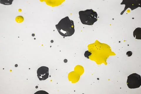 Thick and shiny splashes of black and yellow paint scattered. Stock Photos