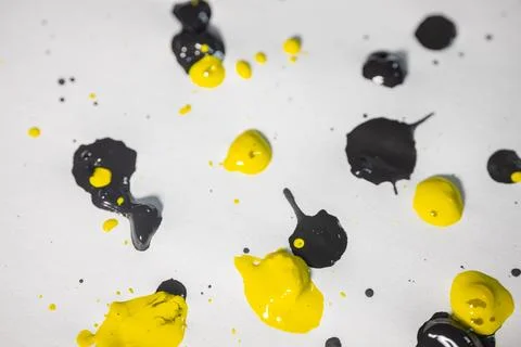 Thick and shiny splashes of black and yellow paint scattered. Stock Photos