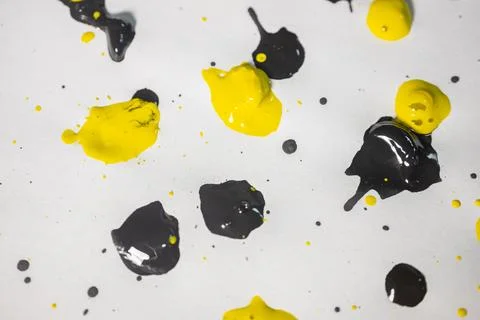 Thick and shiny splashes of black and yellow paint scattered. Stock Photos