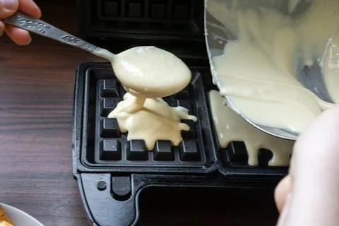 Thick Batter Pouring into Waffle Maker Mold. Stock Photos