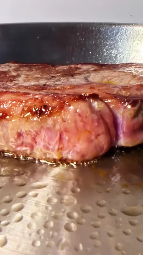 Thick Beef Steak Searing in Round Pan on Induction Cooktop, Dolly Shot Close Up Stock Footage 338173563