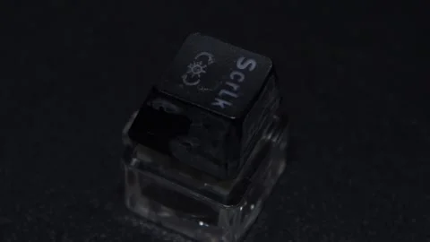 The thick black mechanical keyboard key connected to the blue switch on a black Stock Footage 253822090