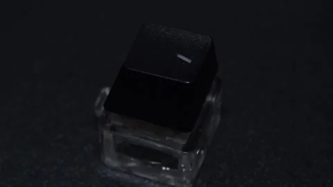 The thick black mechanical keyboard key connected to the blue switch on a black Stock Footage 253822136