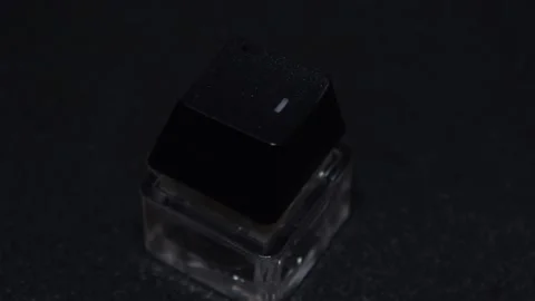 The thick black mechanical keyboard key connected to the blue switch on a black Stock Footage 253822368