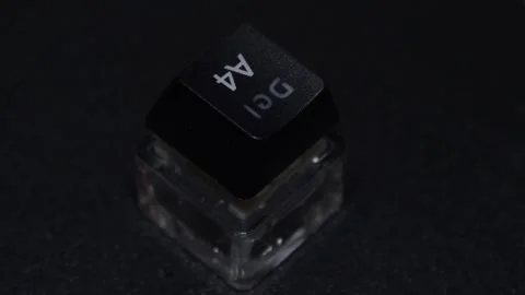 The thick black mechanical keyboard key connected to the blue switch on a black Stock Footage 253822395