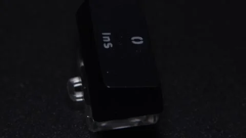 The thick black mechanical keyboard key connected to the blue switch on a black Stock Footage 253822711