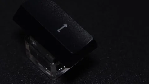 The thick black mechanical keyboard key connected to the blue switch on a black Stock Footage 253823154