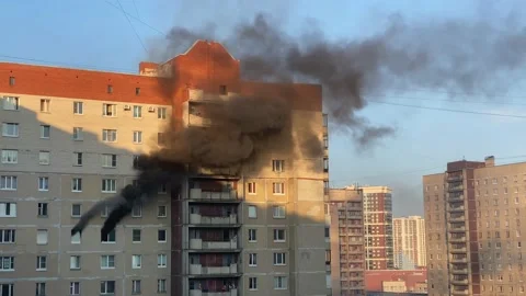 Thick black smoke billows from two windows of an apartment building 库存影片 199274122