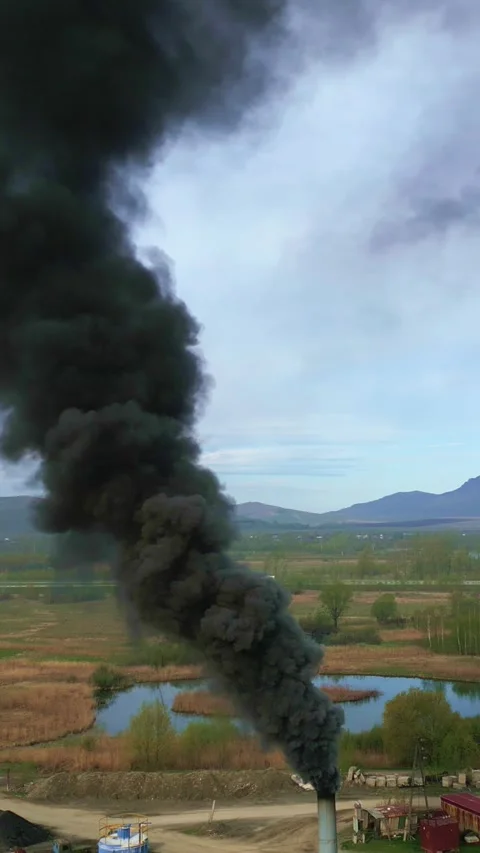 Thick black smoke rises from a distant industrial source Stock Footage 331621329