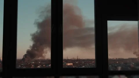 Thick black smoke rises into the sky from a burning after a rocket attack Stock Footage 327216011