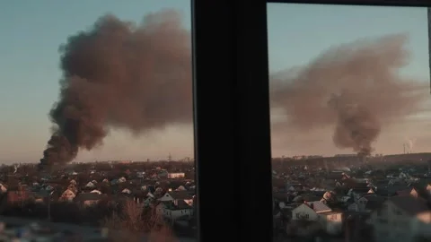 Thick black smoke rises into the sky from a burning after a rocket attack Stock Footage 327216015