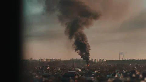 Thick black smoke rises into the sky from a burning after a rocket attack Stock Footage 327216022