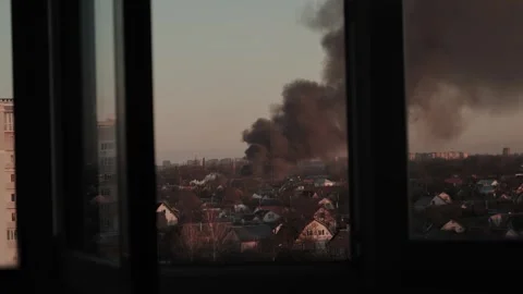 Thick black smoke rises into the sky from a burning after a rocket attack Stock Footage 327216027