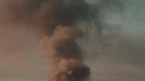 Thick black smoke rises into the sky from a burning after a rocket attack Stock Footage 327216038