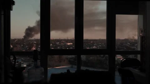 Thick black smoke rises into the sky from a burning after a rocket attack Stock Footage 327216039