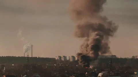 Thick black smoke rises into the sky from a burning after a rocket attack Stock Footage 327216040