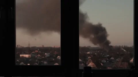 Thick black smoke rises into the sky from a burning after a rocket attack Stock Footage 327216045