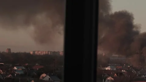Thick black smoke rises into the sky from a burning after a rocket attack Stock Footage 327216046