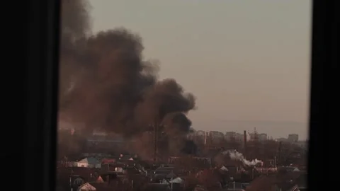 Thick black smoke rises into the sky from a burning after a rocket attack Stock Footage 327216049