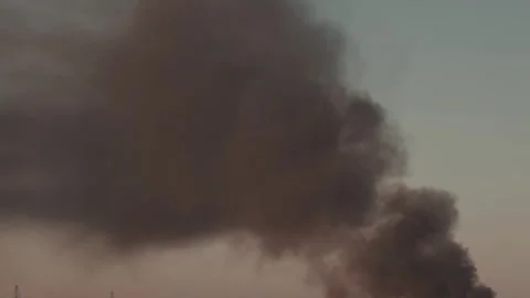Thick black smoke rises into the sky from a burning after a rocket attack Stock Footage 327216051