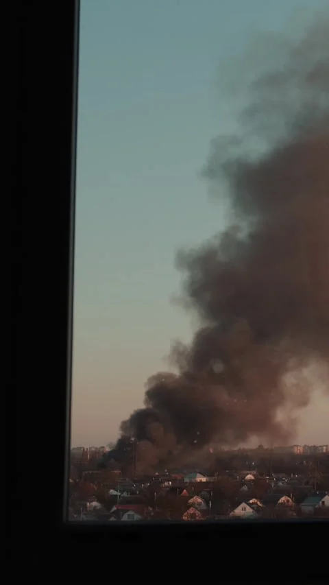 Thick black smoke rises into the sky from a burning after a rocket attack Stock Footage 327216095