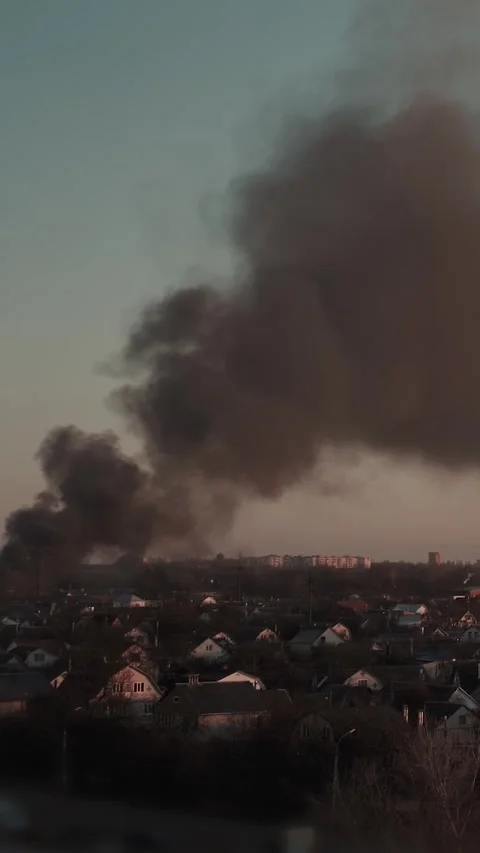 Thick black smoke rises into the sky from a burning after a rocket attack Stock Footage 327216103
