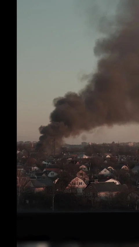 Thick black smoke rises into the sky from a burning after a rocket attack Stock Footage 327216128