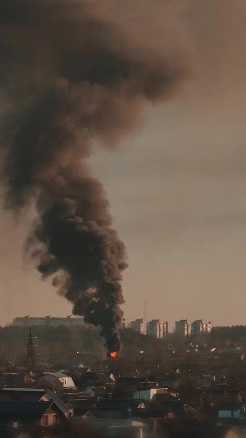 Thick black smoke rises into the sky from a burning after a rocket attack Stock Footage 327216145