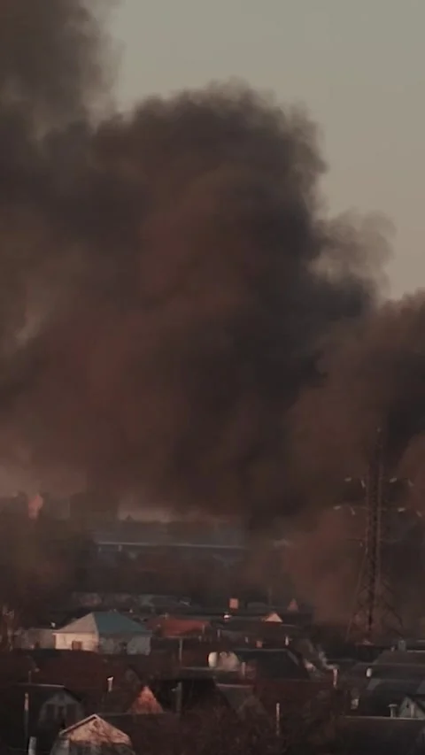 Thick black smoke rises into the sky from a burning after a rocket attack Stock Footage 327216147