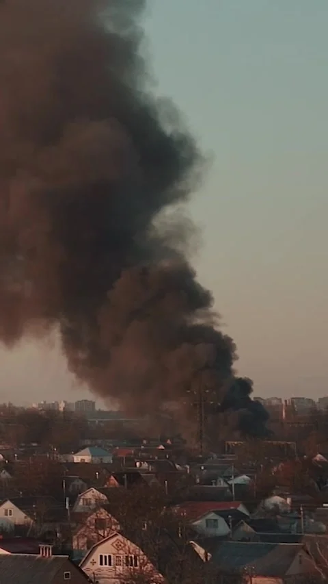 Thick black smoke rises into the sky from a burning after a rocket attack Stock Footage 327216150