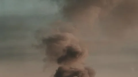 Thick black smoke rises into the sky from a burning building in the city Stock Footage 327301883