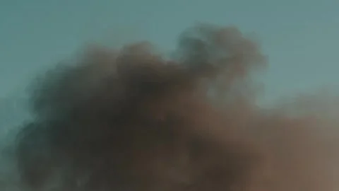 Thick black smoke rises into the sky from a burning building in the city Stock Footage 327301885