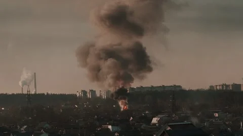 Thick black smoke rises into the sky from a burning building in the city Stock Footage 327301914