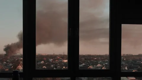Thick black smoke rises into the sky from a burning building in the city Stock Footage 327301916