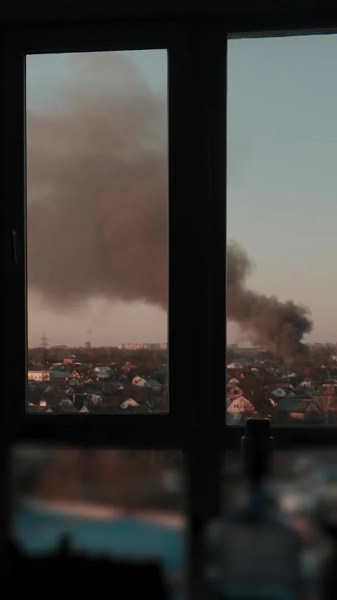 Thick black smoke rises into the sky from a burning building in the city Stock Footage 327301978
