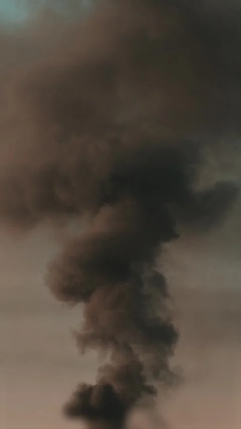 Thick black smoke rises into the sky from a burning building in the city Stock Footage 327301981