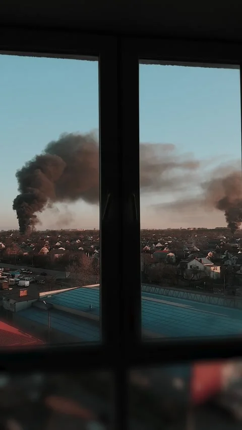 Thick black smoke rises into the sky from a burning building in the city Stock Footage 327301990