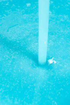 Thick blue soap pouring into a container, concept of laundry or manufacturing Stock Photos