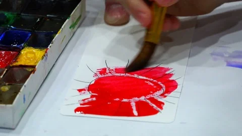 A thick brush with red paint gives a tone to the sun. Stock Footage 76727337